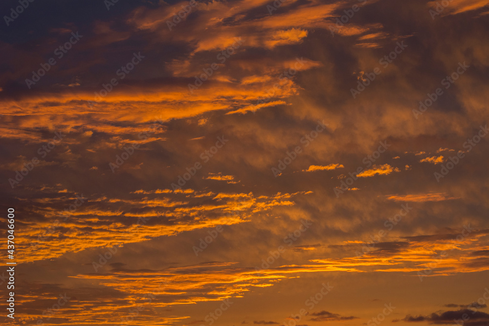 Beautiful orange sundown over the sea. Yellow clouds in the sky in the evening