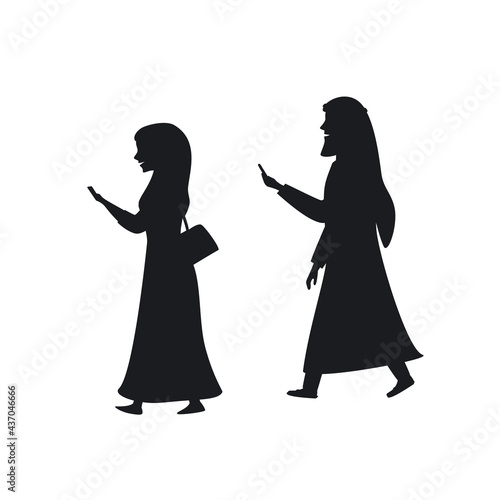 arab man and woman walking with smartphones texting silhouette