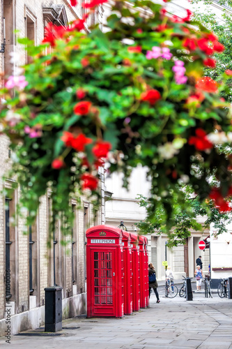 Photography Famous red telephone booths against flowers in Covent Garden street, London, Eng