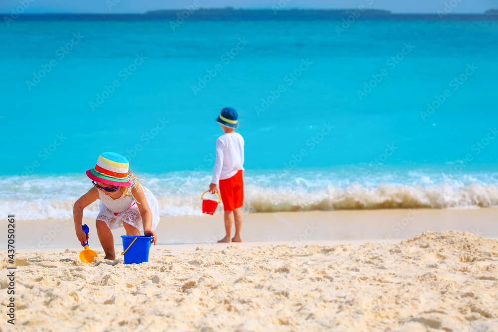 boy and girl play with sand on beach vacation boy and girl play with sand on beach vacation