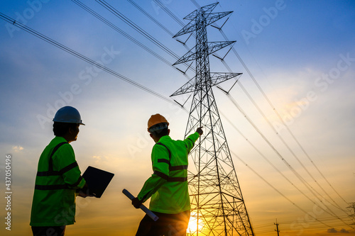 electrical engineer working at the power station See the planning of electricity production at high voltage poles.