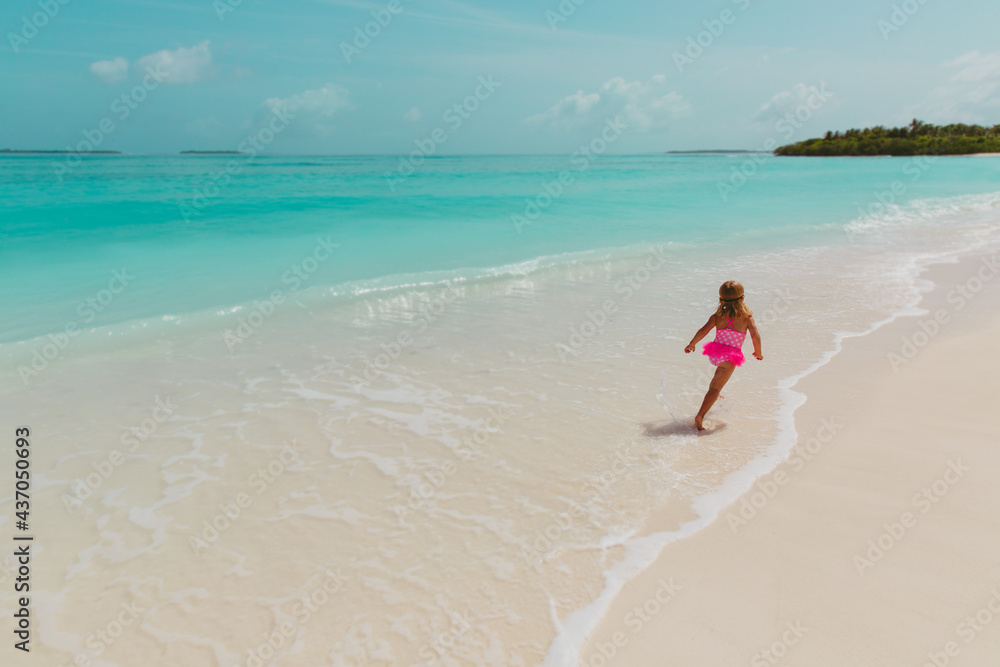 happy little girl play with water on beach, family vacation happy little girl play with water on beach, family vacation