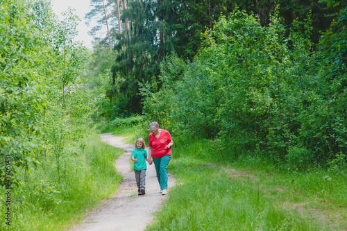 happy senior grandmother with granddaughter walk in nature