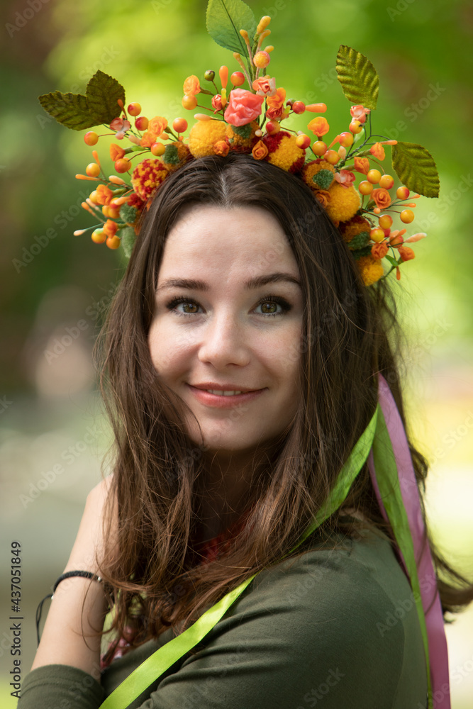 Attractive girl in a green dress, wreath and necklace. Attractive girl in a green dress, wreath and necklace.