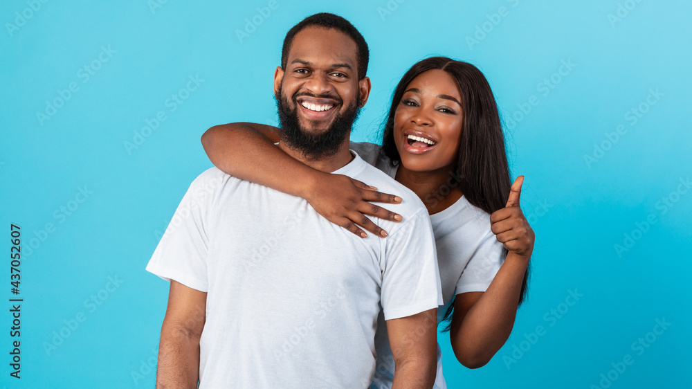 Fototapeta premium Happy afro couple gesturing thumbs up and smiling