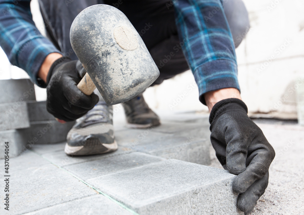 Worker lining paving slabs path Worker lining paving slabs path