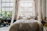 Cozy boho chic bedroom decorated with green plants