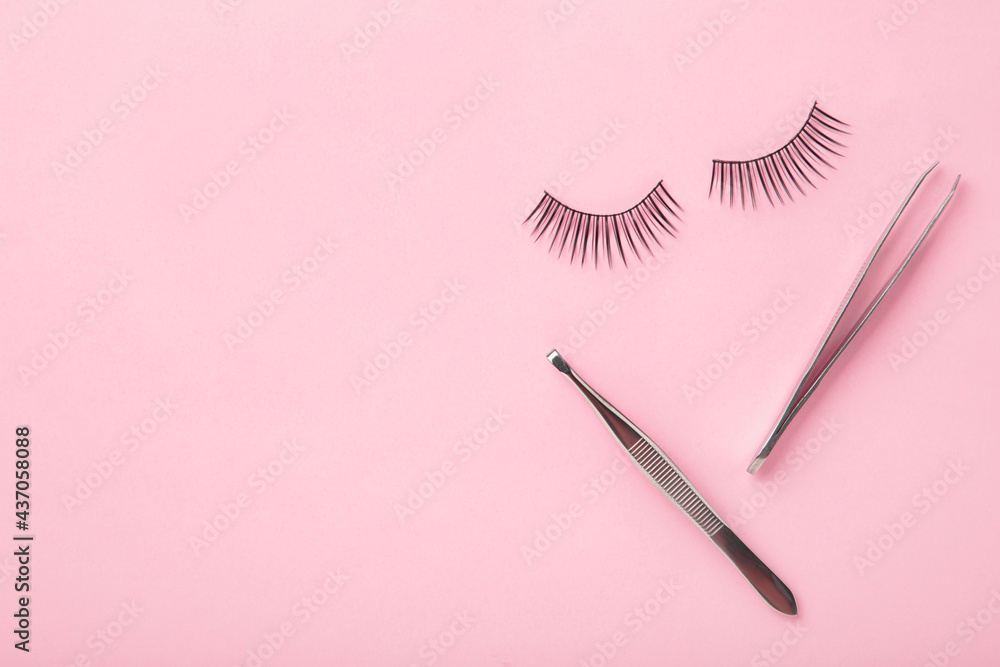 Set of false eyelashes extencions on pink background with tweezers. Minimalism