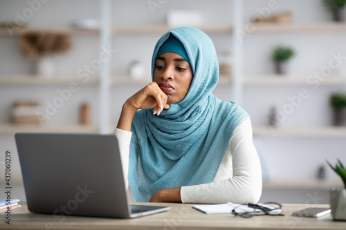 Lack Of Inspiration. Pensive Black Muslim Woman Looking At Laptop Screen