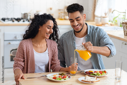 Morning Meal. Arab Spouses Eating Breakfast And Drinking Orange Juice In Kitchen