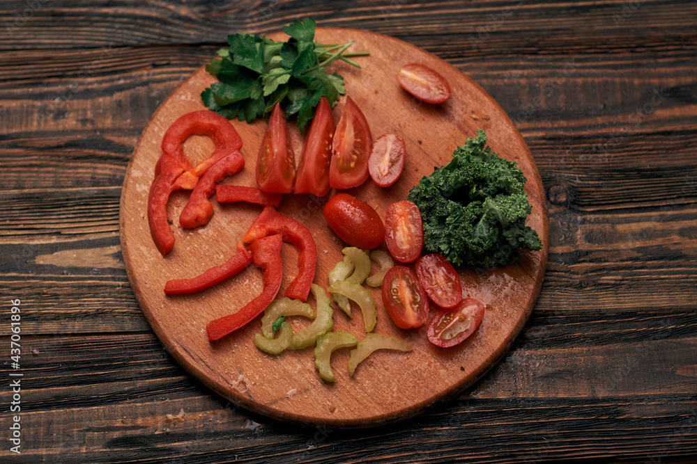 sliced vegetables on a round wooden board. sliced vegetables on a round wooden board.