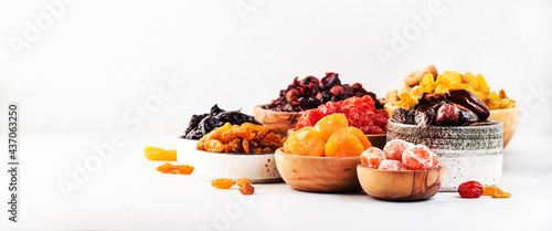 Fotografie Healthy food snacks: natural dried fruits mix in bowls on white background