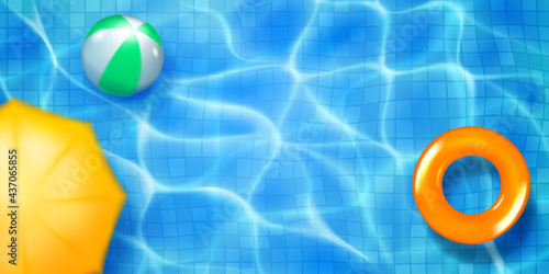 Swimming pool top view with mosaic tiles, inflatable ring, ball and sun awning. Water surface in light blue colors with sunlight glares and caustic ripples. Summer holiday background.