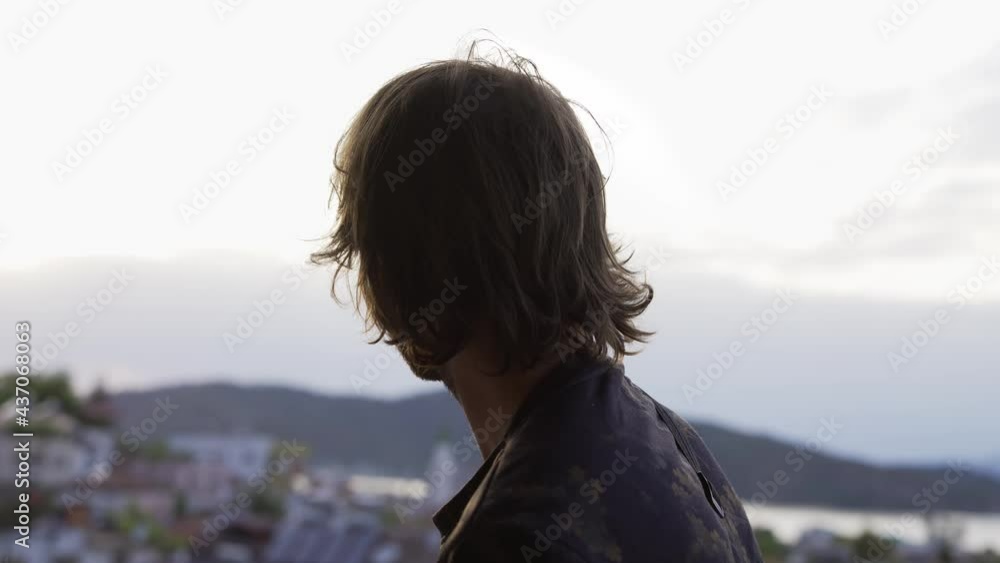 Rear view of a man, stunning panoramic views of the city, the bay of the sea and mountains Rear view of a man, stunning panoramic views of the city, the bay of the sea and mountains