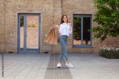 Sales and discounts. Woman with shopping bags outdoors. Satisfied customer with purchases. © Andrii Zastrozhnov