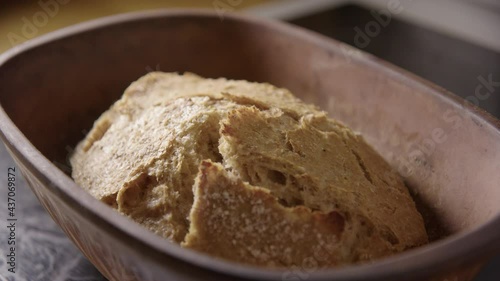 BAKING - Uncovering sourdough bread fresh from the oven, slow motion close up photo