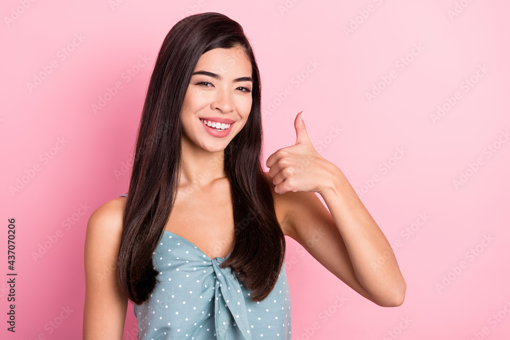 Portrait of attractive cheerful woman showing thumbup ad advert isolated over pink pastel color background Portrait of attractive cheerful woman showing thumbup ad advert isolated over pink pastel color background