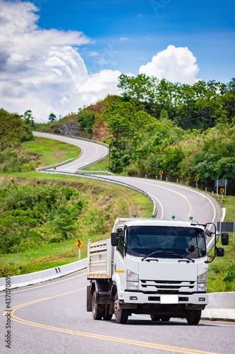 Big truck driving on beautiful wavy road along the mountain