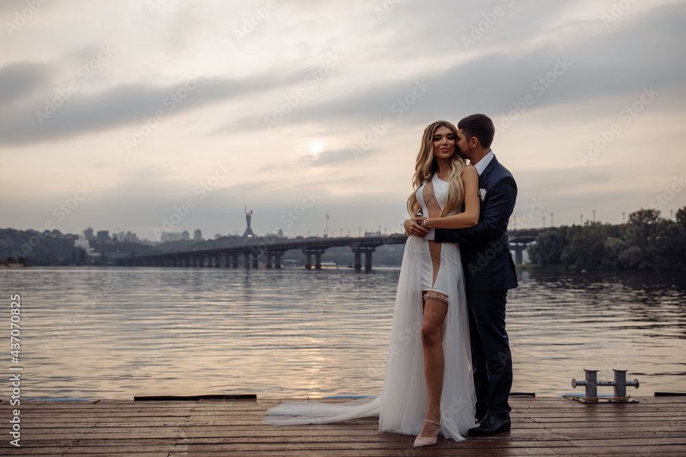 Walk for the newlyweds on the banks of the Dnieper. Photo session by the river. Summer evening. Walk for the newlyweds on the banks of the Dnieper. Photo session by the river. Summer evening.