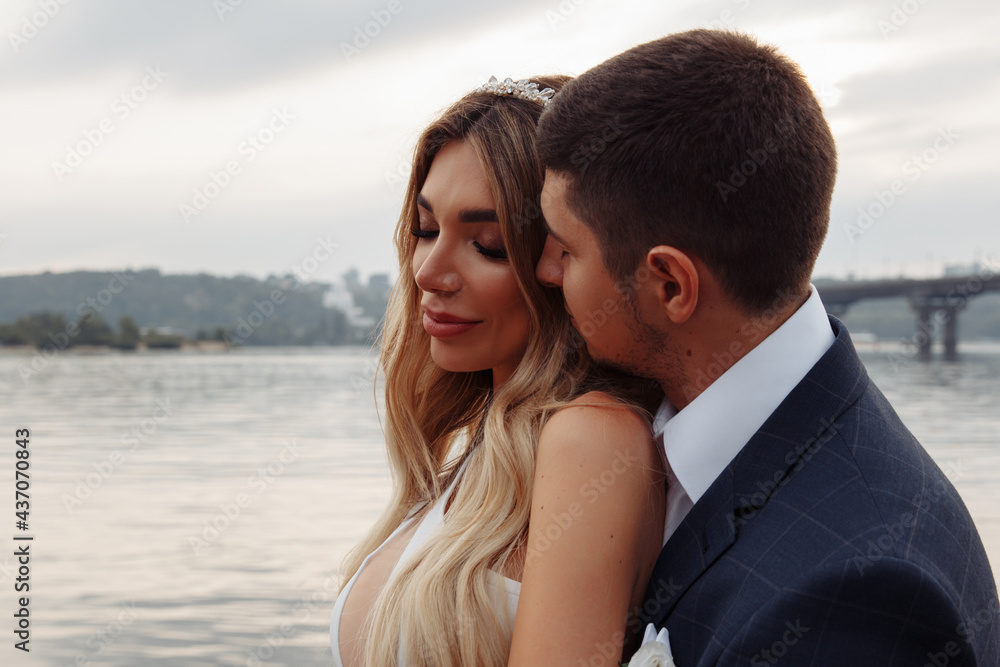 Walk for the newlyweds on the banks of the Dnieper. Photo session by the river. Summer evening. Walk for the newlyweds on the banks of the Dnieper. Photo session by the river. Summer evening.
