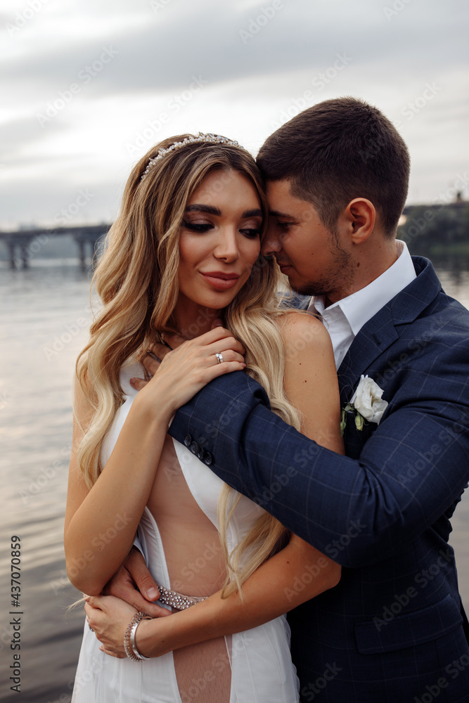 Walk for the newlyweds on the banks of the Dnieper. Photo session by the river. Summer evening. Walk for the newlyweds on the banks of the Dnieper. Photo session by the river. Summer evening.
