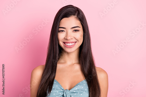 Portrait of attractive cheerful long-haired woman wearing dotted top isolated over pink pastel color background