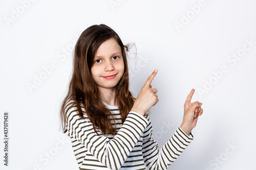 Funny dark-haired girl shows gesture with her hands. On a light background. Place for text 