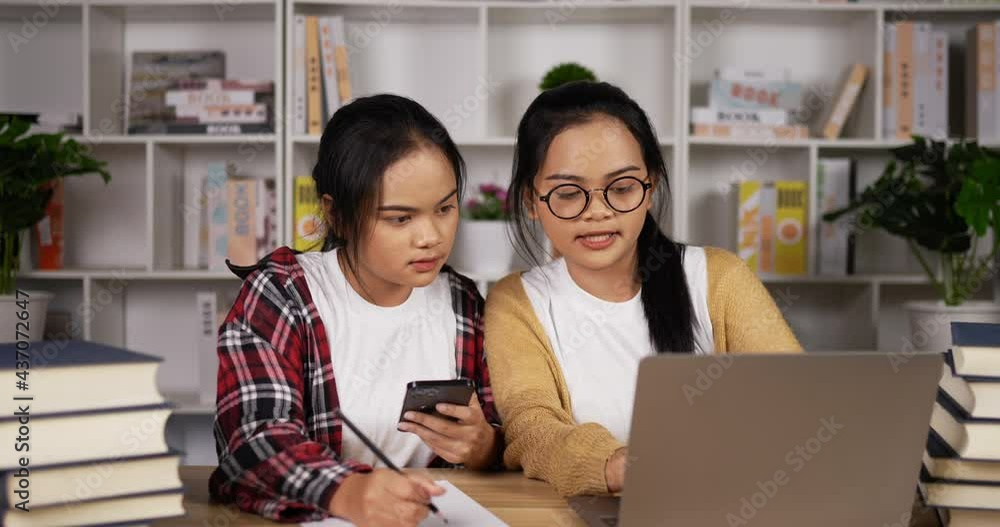 Twin asian girls using laptop and smartphone to learning online Twin asian girls using laptop and smartphone to learning online