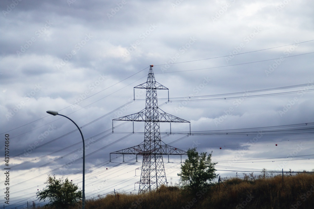 Torres de alta tensión para conducir la electricidad. Fotografía tomada un  día nublado donde destaca la silueta con el cielo oscuro. Stock Photo