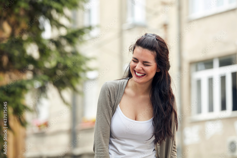 Fototapeta premium Young cute female smiling and laughing on the street.