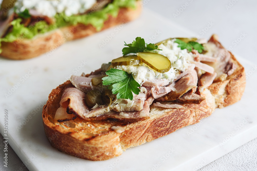 Roast beef, pickle and cheese with remoulade (danish tartar sauce) Smorrebrod. Danish open faced sandwich. Selective focus Roast beef, pickle and cheese with remoulade (danish tartar sauce) Smorrebrod. Danish open faced sandwich. Selective focus