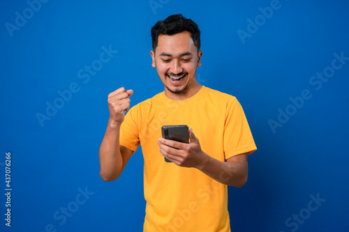 Happy teenager using smarphone with smile and surprised face expression.