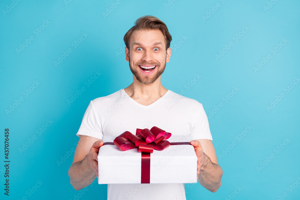 Photo of impressed positive person arms hold receiving giftbox open mouth isolated on blue color background Photo of impressed positive person arms hold receiving giftbox open mouth isolated on blue color background