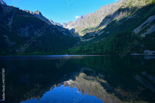 The beautiful lake Popradske pleso in the High Tatras in the evening sun with a reflection of the mountains. Slovakia.