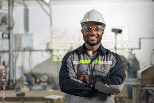 Φωτογραφία Portrait of African American male engineer in uniform smiling and standing cross