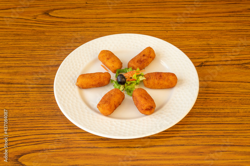 Typical Spanish tapa of ham croquettes with a little bit of garnish in the center