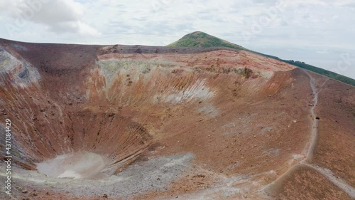 Aerial view of volcano crater and sulfuric smokes on Volcano Island travel destination in Sicily, Aeolian Islands. Revealing parallax shot video drone