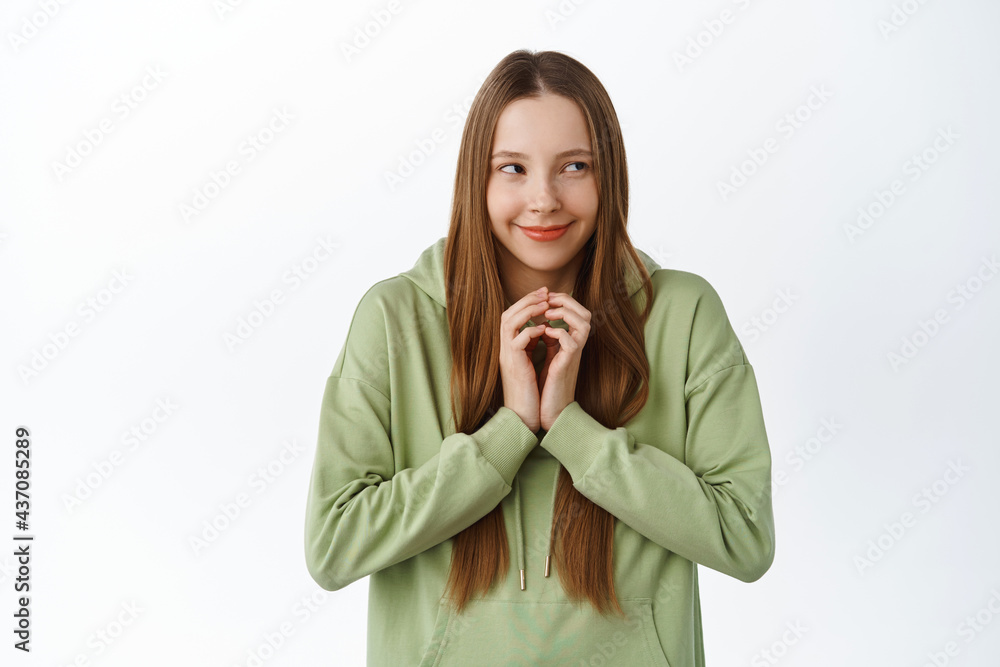 Evil genius. Cunning young woman have interesting plan, steeple fingers as scheming and looking aside, think up scheme, standing over white background Evil genius. Cunning young woman have interesting plan, steeple fingers as scheming and looking aside, think up scheme, standing over white background