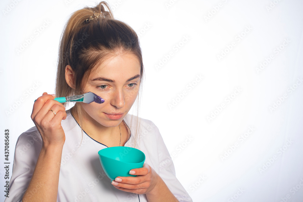 Woman applies a cosmetic mask on her face. Woman applies a cosmetic mask on her face.