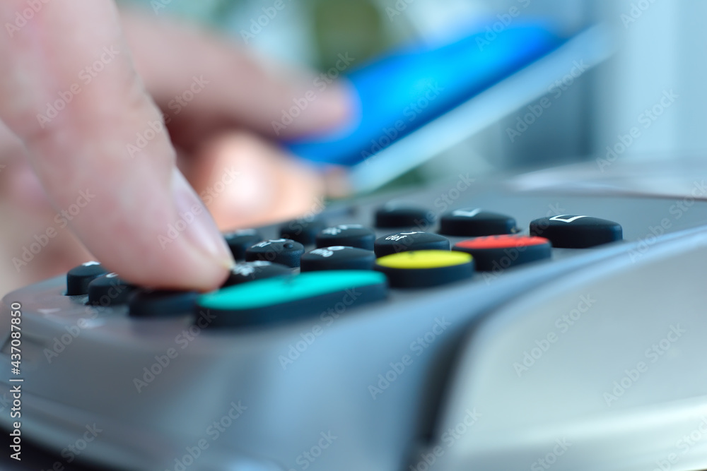 Finger dials pin code on terminal. Finger dials pin code on terminal.