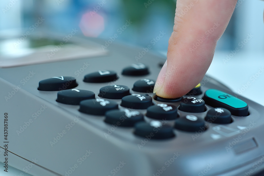 Hand dials pin code on pos terminal. Hand dials pin code on pos terminal.