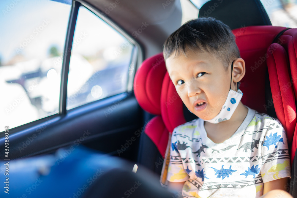 Young Asian Boy Eating a Snack in a Car Seat Young Asian Boy Eating a Snack in a Car Seat