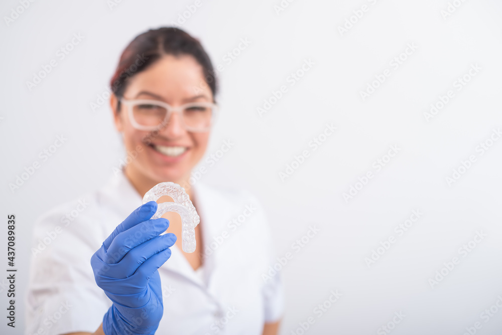 The orthodontist holds the removable transparent retainers The orthodontist holds the removable transparent retainers