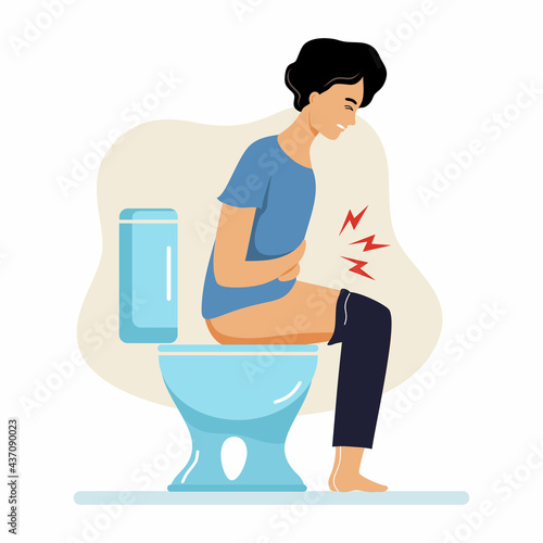 Young man is sitting on  toilet. Problems with constipation and digestion.