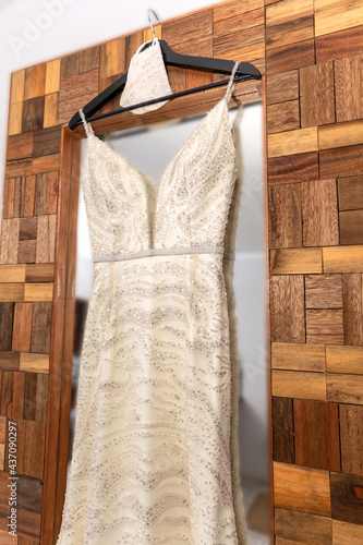 Wedding dress hanging against a mirror
