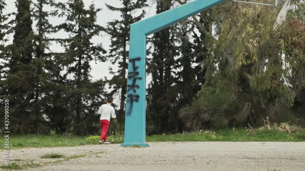 Caucasian boy playing basketball on a basket court at fields , Kifissia, Athens , Greece 120fps Caucasian boy playing basketball on a basket court at fields , Kifissia, Athens , Greece 120fps