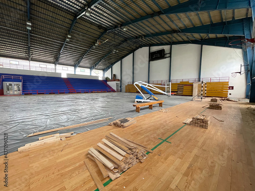 Construction site of sports hall, basketball court renovation, school gym indoor changing hardwood parquet flor and insulation. photo