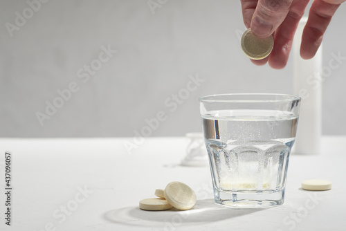 Fizzy tablets, dissolving in the glass of water. Isotonic drink, sport nutrition or medicine solution preparing photo.