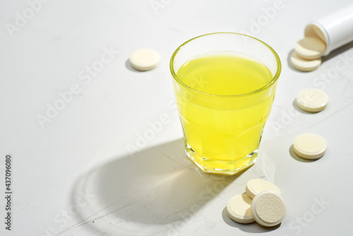 Fizzy tablets, dissolving in the glass of water. Isotonic drink, sport nutrition or medicine solution preparing photo.
