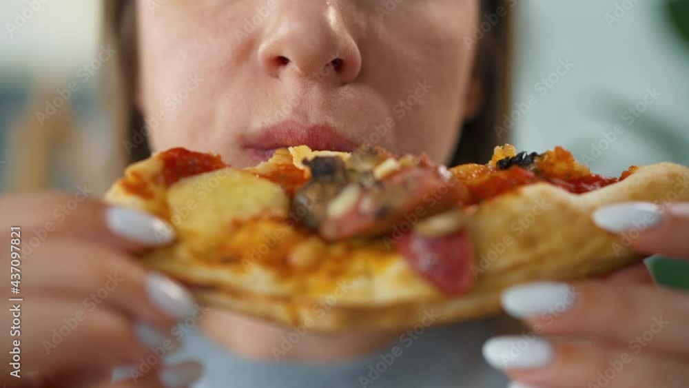 Woman eating pizza. Close-up. Concept of quick bites and unhealthy food Woman eating pizza. Close-up. Concept of quick bites and unhealthy food